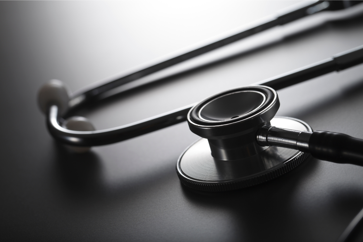 A Close-up Of A Stethoscope Lying On A Smooth, Dark Surface, With Soft Lighting Highlighting Its Metal Chestpiece And Tubing. A Close-up Of A Stethoscope Lying On A Smooth, Dark Surface, With Soft Lighting Highlighting Its Metal Chestpiece And Tubing.